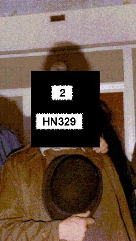 Redacted photo of HN329 'John Graham' holding a hat